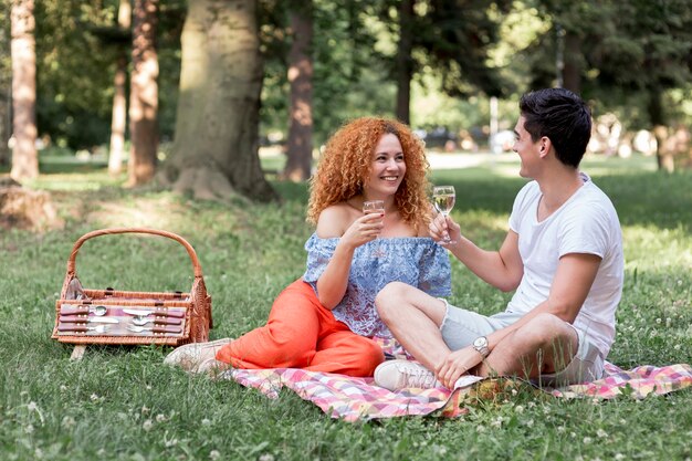 Pareja feliz descansando en una manta en el parque