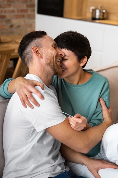 Foto gratuita una pareja feliz descubre que van a ser padres gracias a una prueba de embarazo