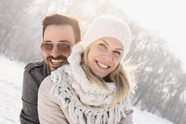 Pareja feliz disfrutando de la hermosa nieve capturada en un día frío y nevado