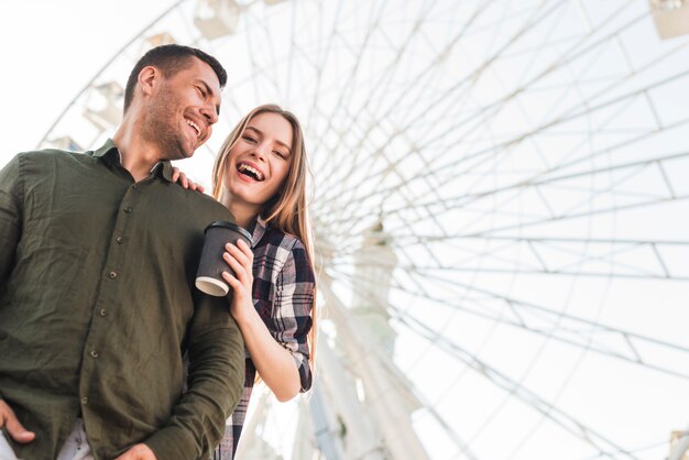 Pareja feliz disfrutando en el parque de atracciones