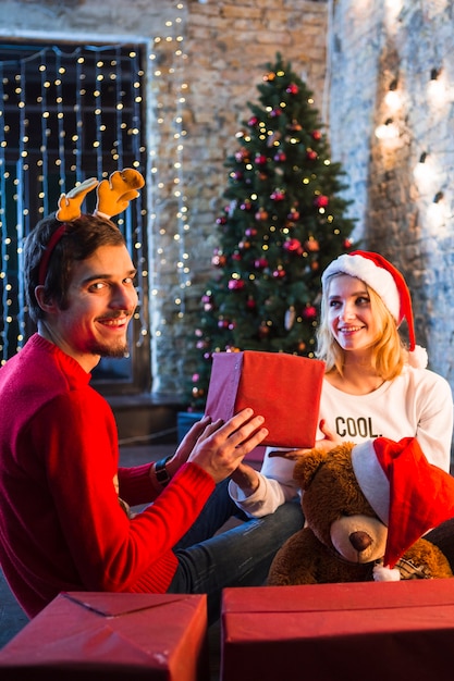 Pareja feliz enfrente de árbol de navidad