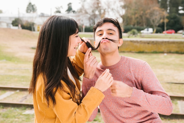 Foto gratuita pareja feliz engañando al aire libre