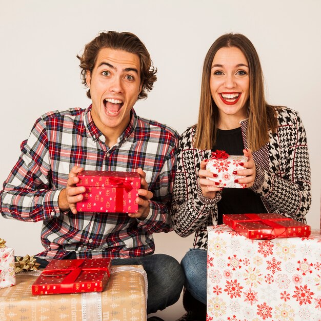 Pareja feliz enseñando cajas de regalos