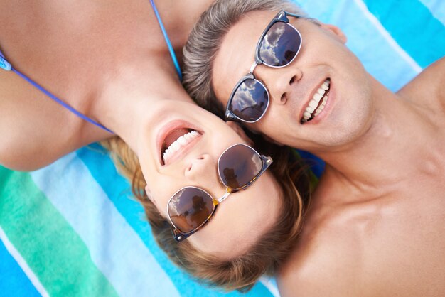 Pareja feliz con gafas de sol en la playa