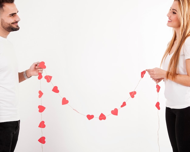 Foto gratuita pareja feliz con guirnalda de corazón