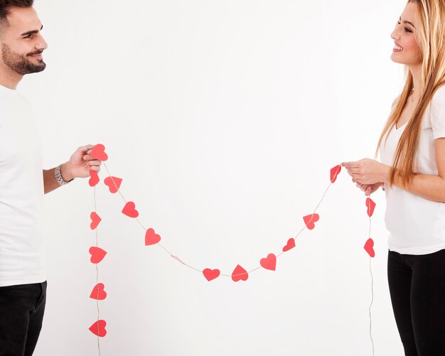 Pareja feliz con guirnalda de corazón