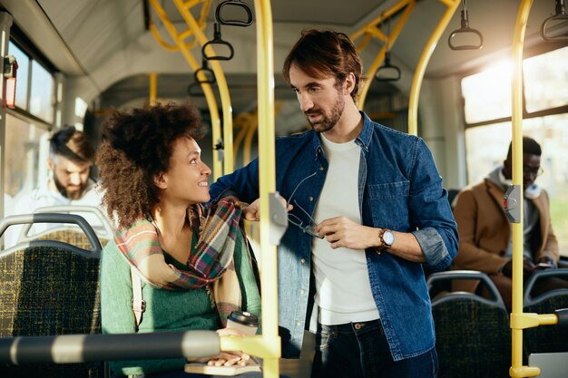 Una pareja feliz hablando entre ellos mientras viajan en autobús