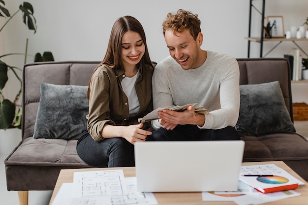 Pareja feliz haciendo planes para remodelar la casa juntos