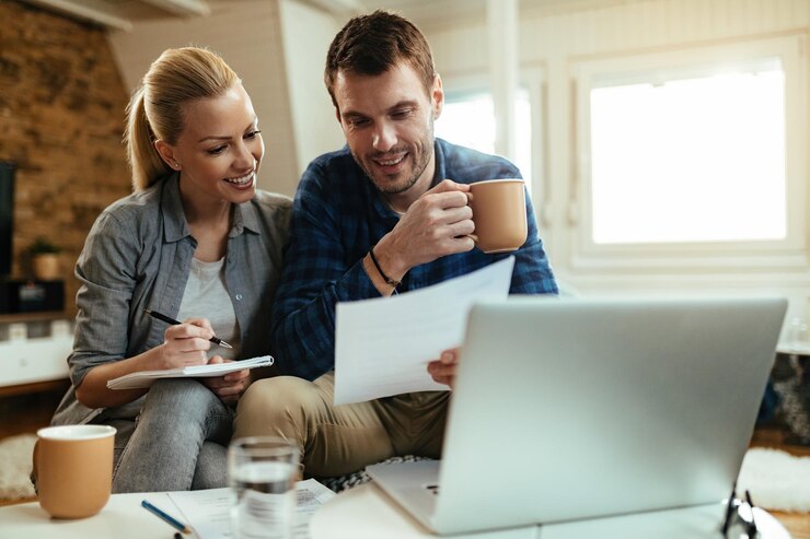 Foto gratuito una pareja feliz haciendo el presupuesto de su hogar mientras revisan las finanzas juntos