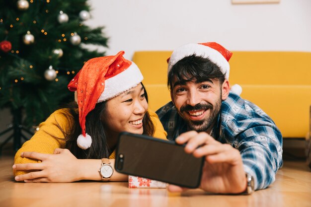 Pareja feliz haciendo selfie en navidad