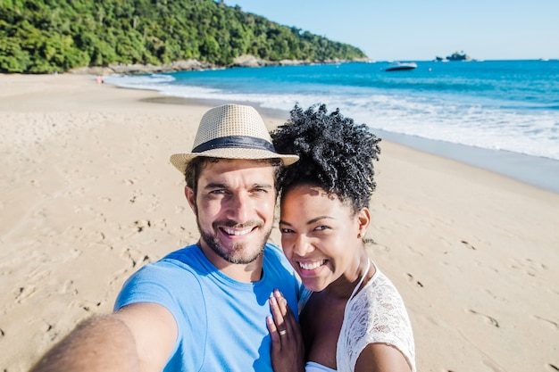 Pareja feliz haciendo un selfie en la playa