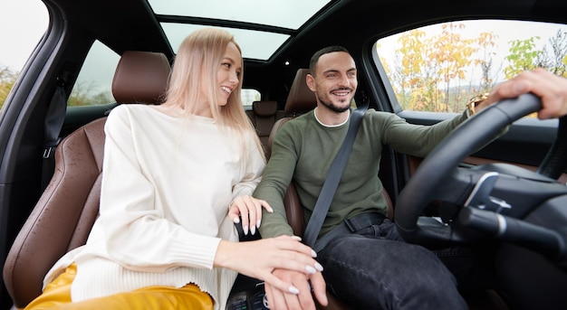 Pareja feliz hombre y mujer viajando en coche