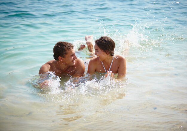 Pareja feliz jugando en el agua