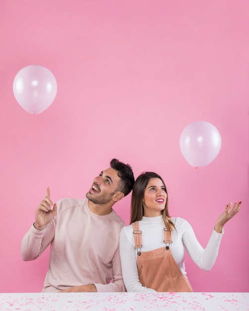 Pareja feliz jugando con globos blancos