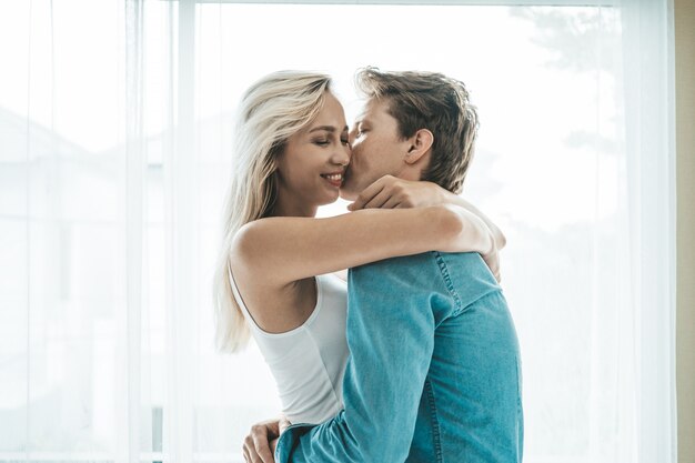 Pareja feliz jugando juntos en el dormitorio