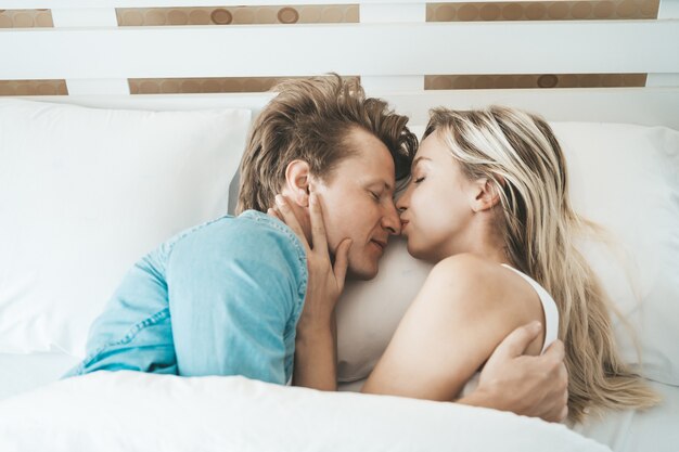 Pareja feliz jugando juntos en el dormitorio