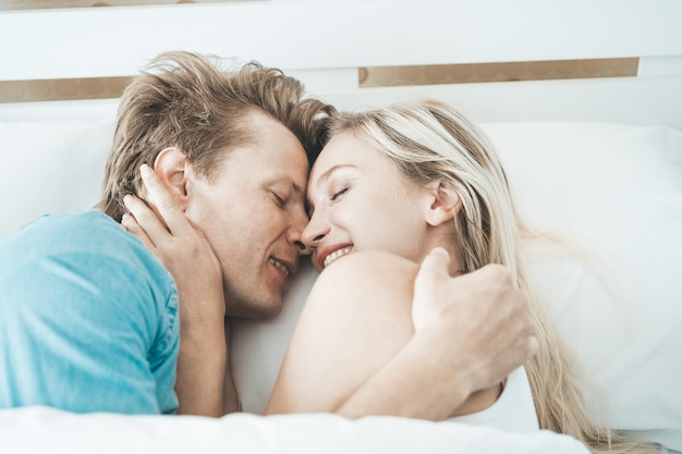 Pareja feliz jugando juntos en el dormitorio