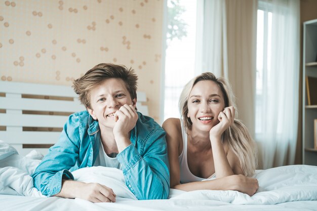 Pareja feliz jugando juntos en el dormitorio