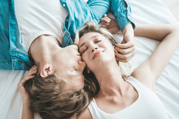 Pareja feliz jugando juntos en el dormitorio