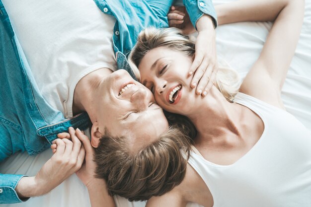 Pareja feliz jugando juntos en el dormitorio