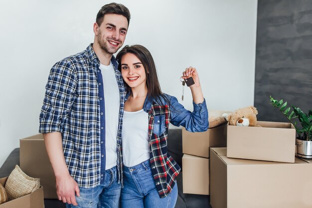 Pareja feliz con llaves de apartamentos nuevos