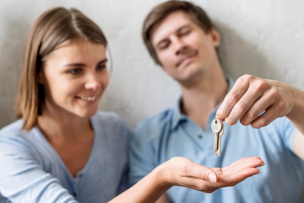 Pareja feliz con llaves de propiedad antigua