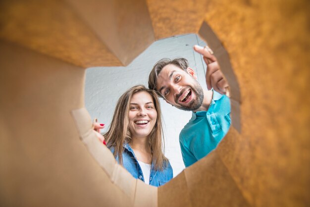 Pareja feliz mirando dentro de la bolsa de papel