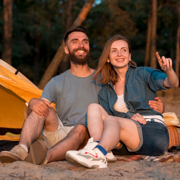 Pareja feliz mirando a otro lado por carpa