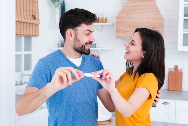 Pareja feliz mostrando prueba de embarazo