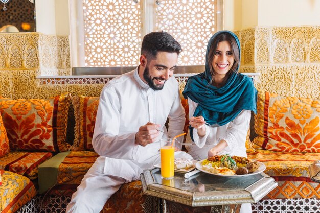 Pareja feliz musulmana en restaurante arabe