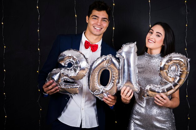 Pareja feliz con números de globos