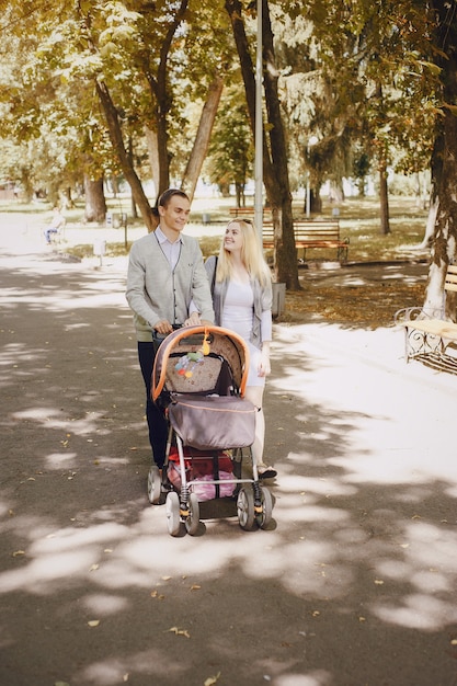 Pareja feliz paseando a su bebé