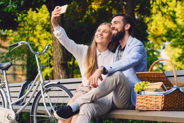 Pareja feliz en un picnic hace selfie.