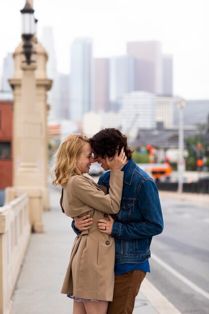 Pareja feliz posando al aire libre en la ciudad con anillo de compromiso