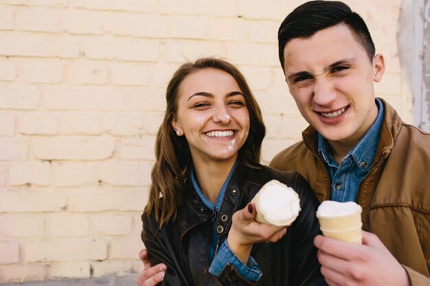 Pareja feliz posando con helado en la cara