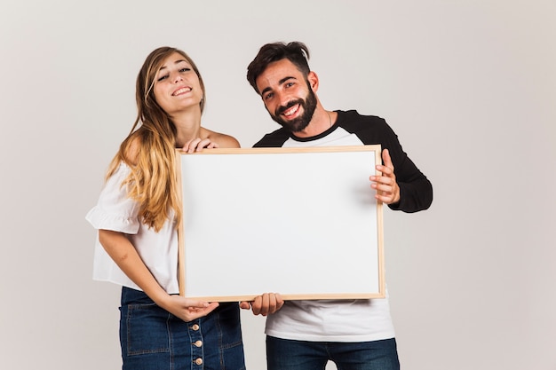 Pareja feliz presentando tabla