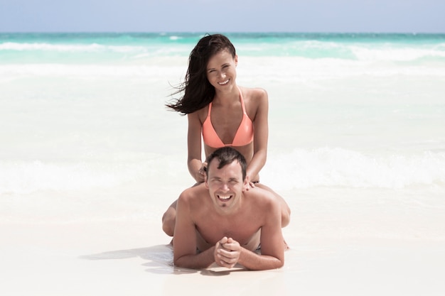 Pareja feliz sentada en la playa