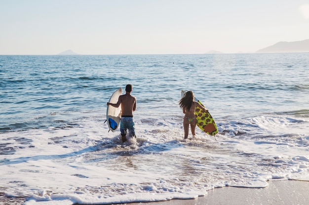 Foto gratuita pareja feliz surfeando