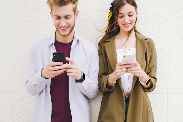 Pareja feliz con teléfono inteligente al aire libre
