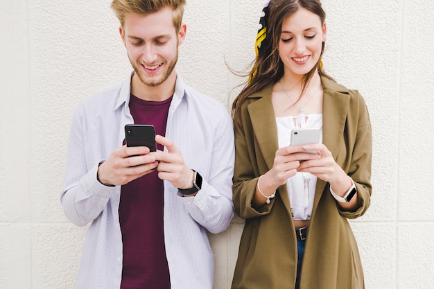 Foto gratuita pareja feliz con teléfono inteligente al aire libre