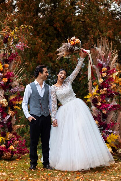 Pareja feliz de tiro completo con flores