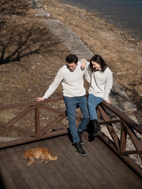 Pareja feliz de tiro completo y lindo perro