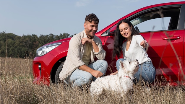 Foto gratuita pareja feliz de tiro completo con perro