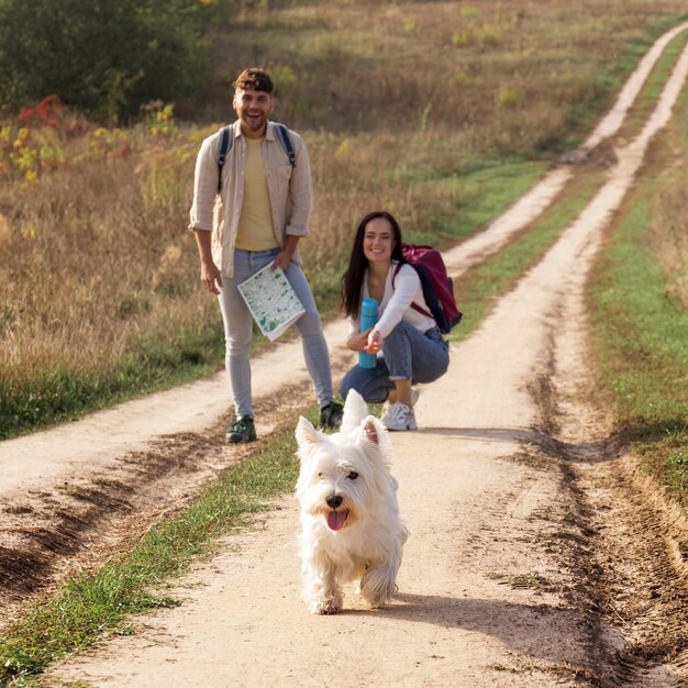 Pareja feliz de tiro completo con perro