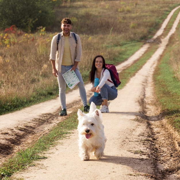 Pareja feliz de tiro completo con perro