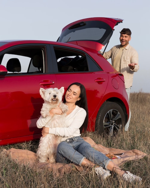 Foto gratuita pareja feliz de tiro completo con perro