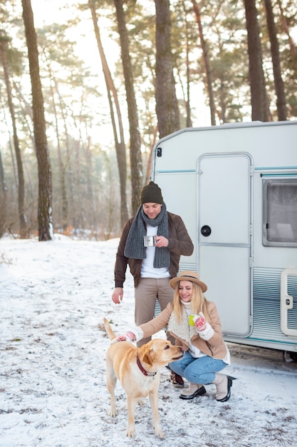 Pareja feliz de tiro completo con perro