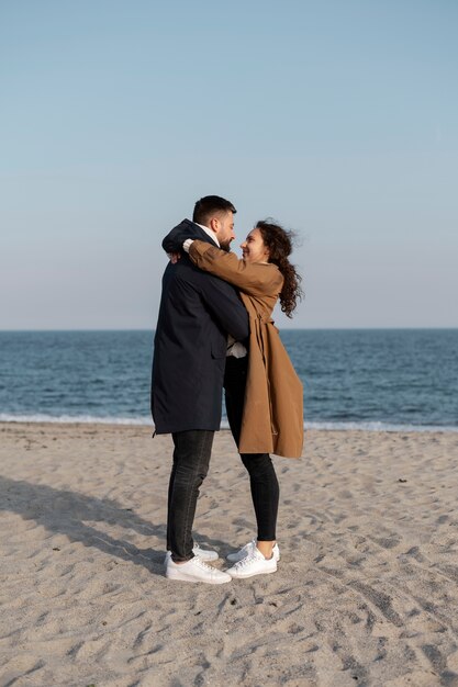 Pareja feliz de tiro completo en la playa