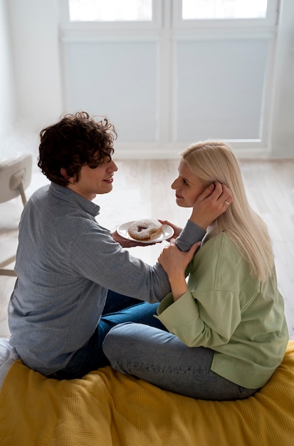 Foto gratuita pareja feliz de tiro completo con postre