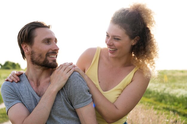 Pareja feliz de tiro medio al aire libre